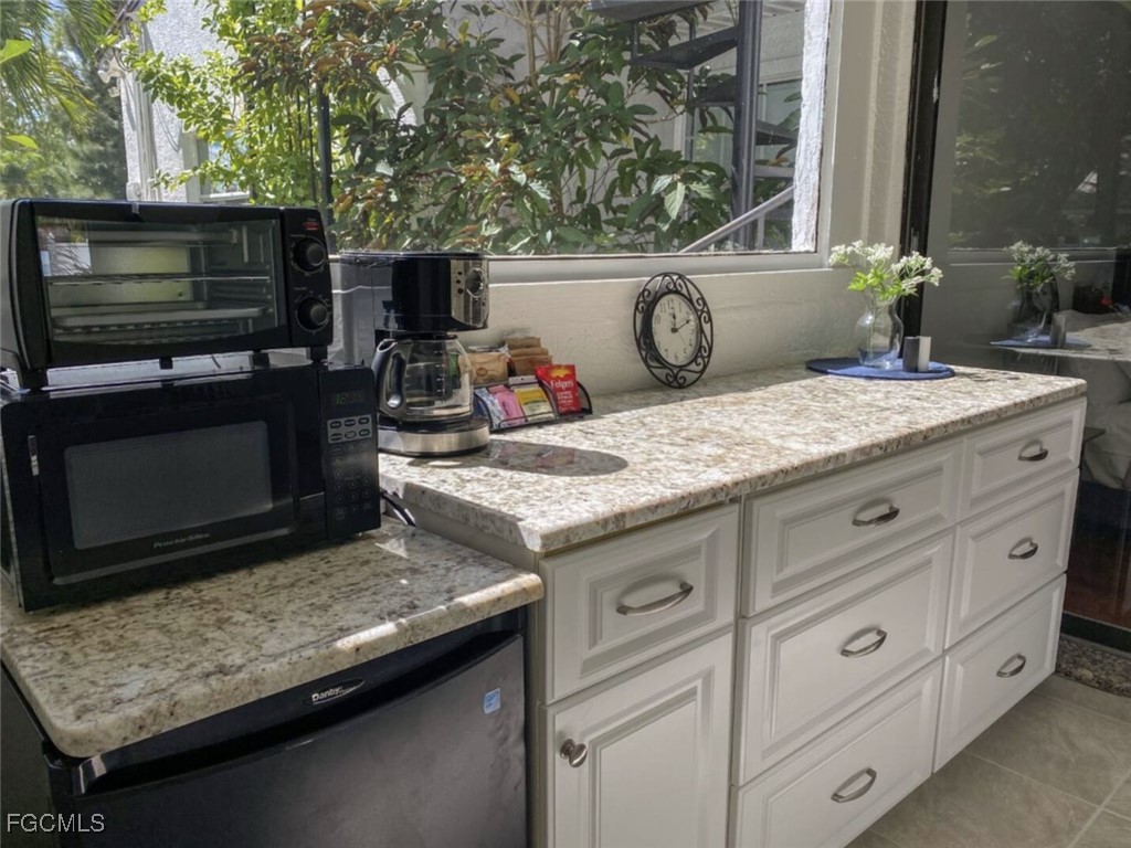 6343 Mark Lane Fort Myers, FL 33966 - Photo 34 of 37 a kitchen with a stove microwave and cabinets