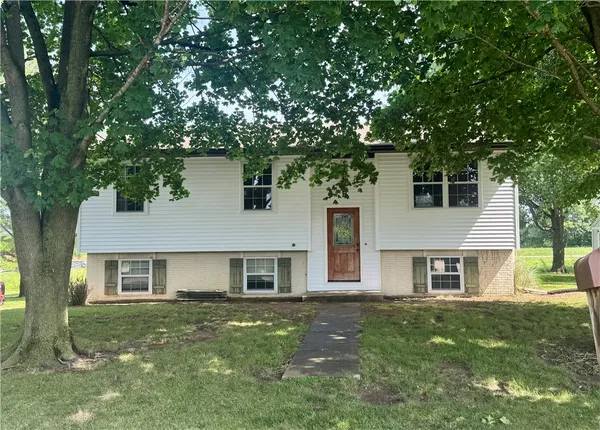 a front view of a house with a garden and yard