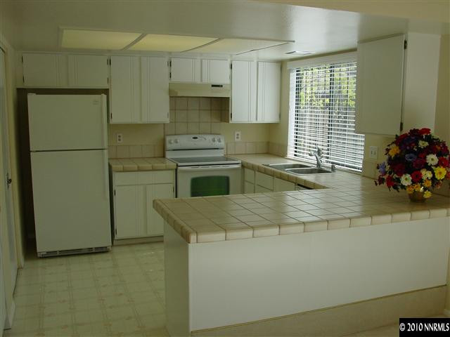 1451 Foster Drive Reno, NV 89509 - Photo 4 of 13 a kitchen with stainless steel appliances a sink stove and refrigerator