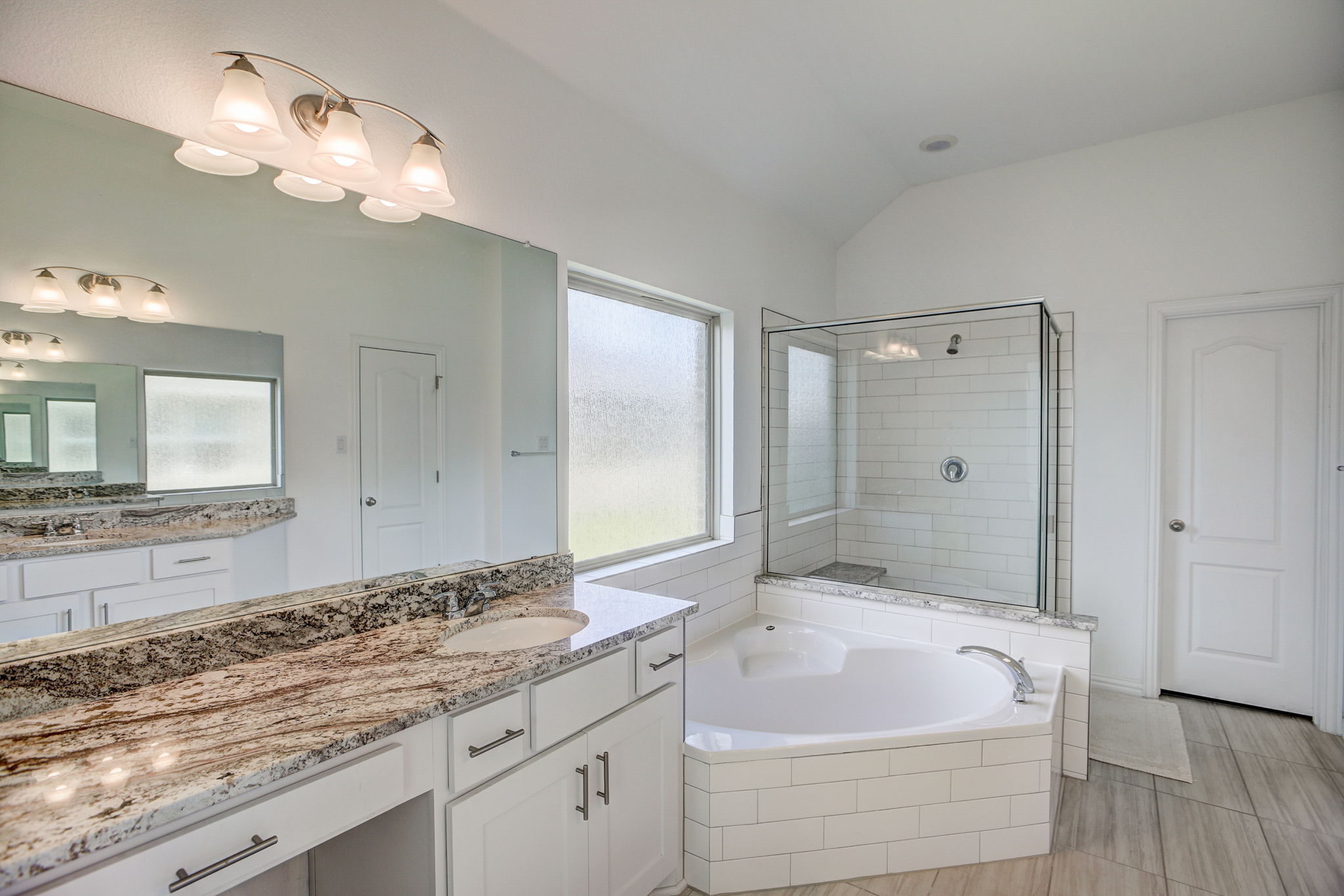 308 Monteforte Road Hutto, TX 78634 - Photo 16 of 32 a bathroom with a tub a sink and a mirror