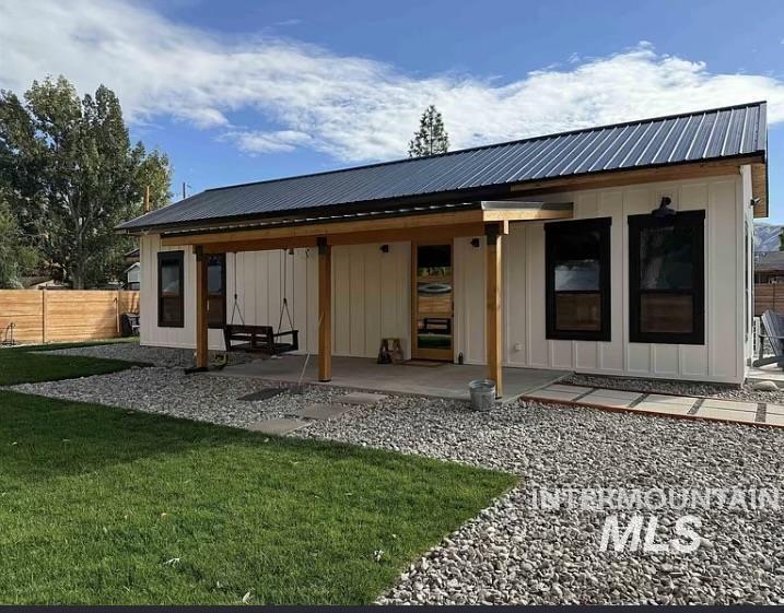 Back of house featuring board and batten siding and a metal roof
