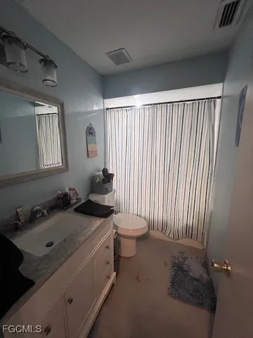 a bathroom with a sink toilet and window