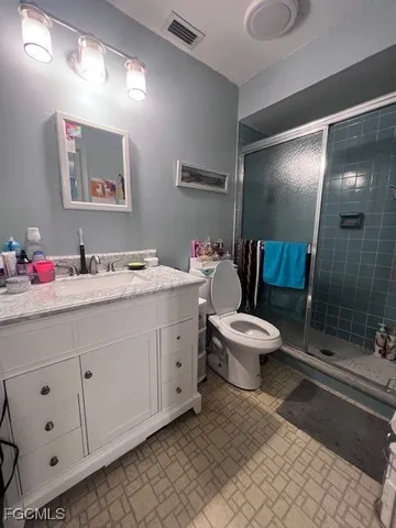 a bathroom with a double vanity sink mirror and toilet