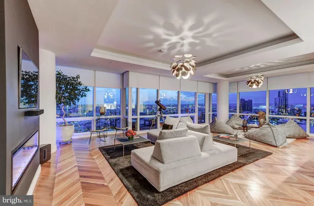 a living room with furniture kitchen view and large windows