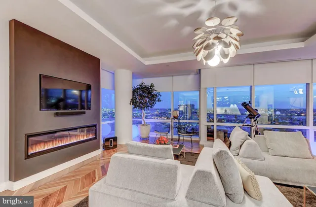 a living room with furniture a chandelier and a flat screen tv