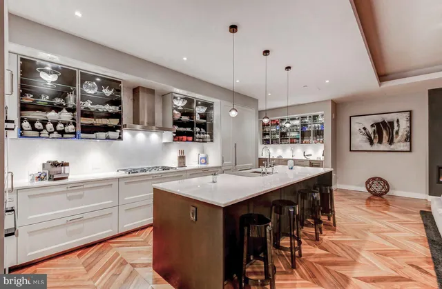 a kitchen with stainless steel appliances granite countertop a sink a stove and chairs