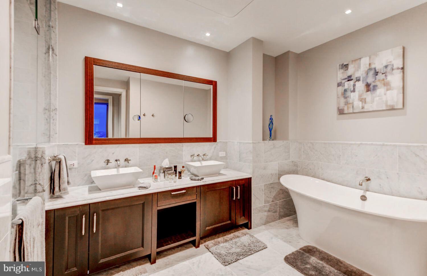 300 International Drive, Unit 2301 Baltimore, MD 21202 - Photo 31 of 37 a bathroom with a double vanity sink mirror and bathtub