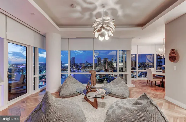 a living room with furniture a chandelier and a dining table