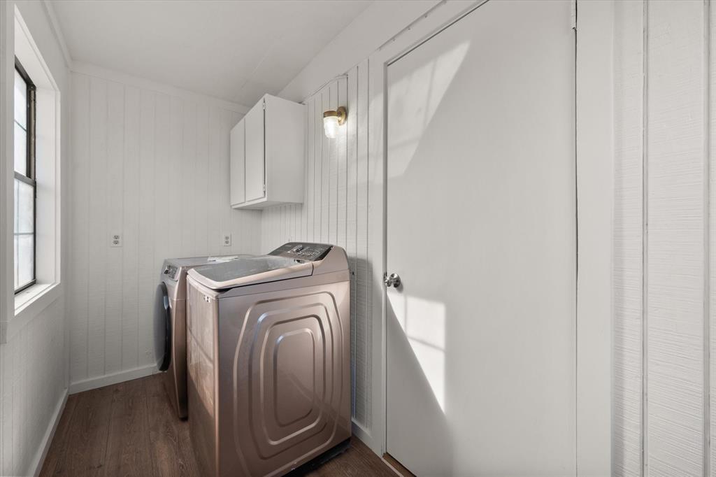 443 County Road 3799 Springtown, TX 76082 - Photo 26 of 33 Laundry room with dark wood-type flooring, washing machine and clothes dryer, cabinet space, and wood walls
