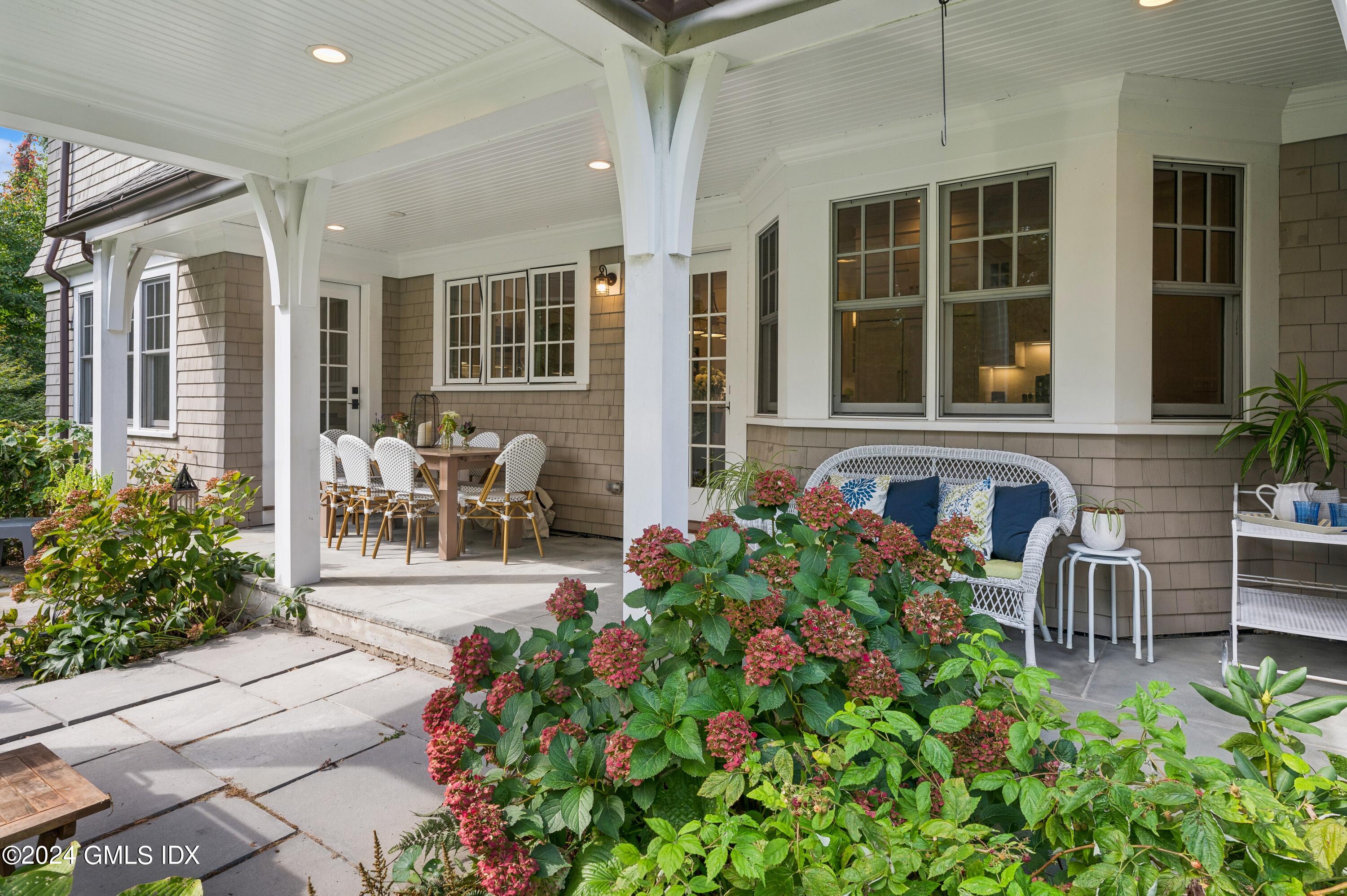 155 Cat Rock Road Cos Cob, CT 06807 - Photo 26 of 29 a front view of a house with outdoor seating and potted plants