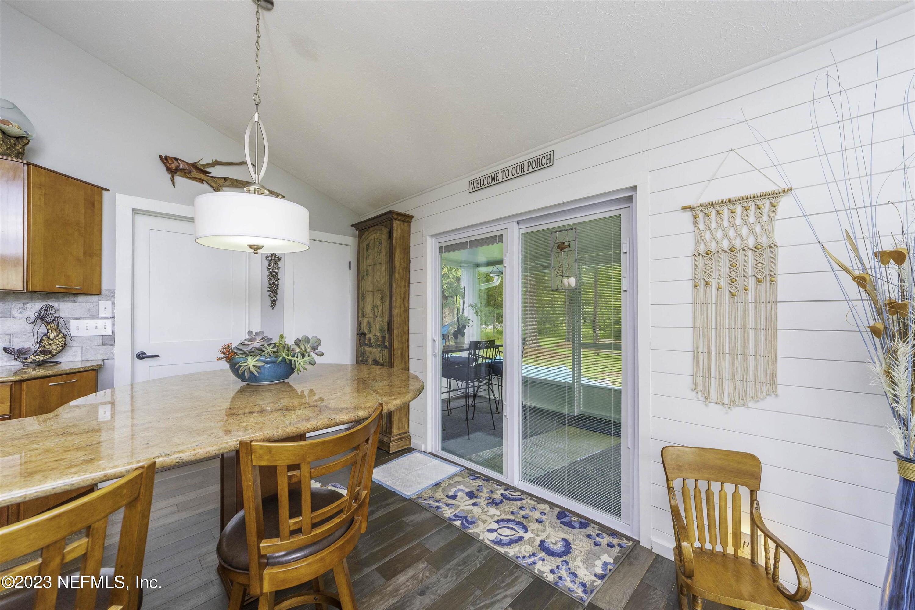 111 Loyola Road St. Augustine, FL 32086 - Photo 18 of 67 a dining room with wooden floor and a chandelier
