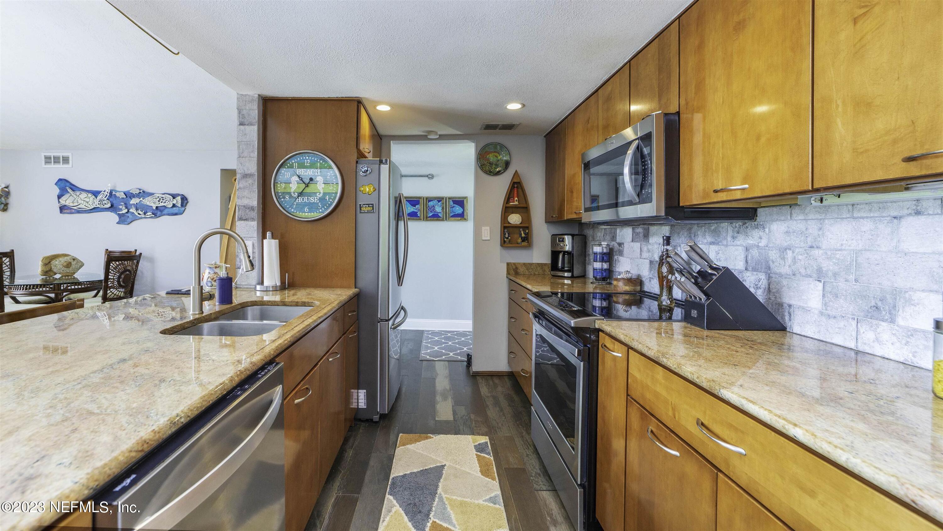 111 Loyola Road St. Augustine, FL 32086 - Photo 21 of 67 a kitchen with stainless steel appliances granite countertop a stove a sink and a refrigerator