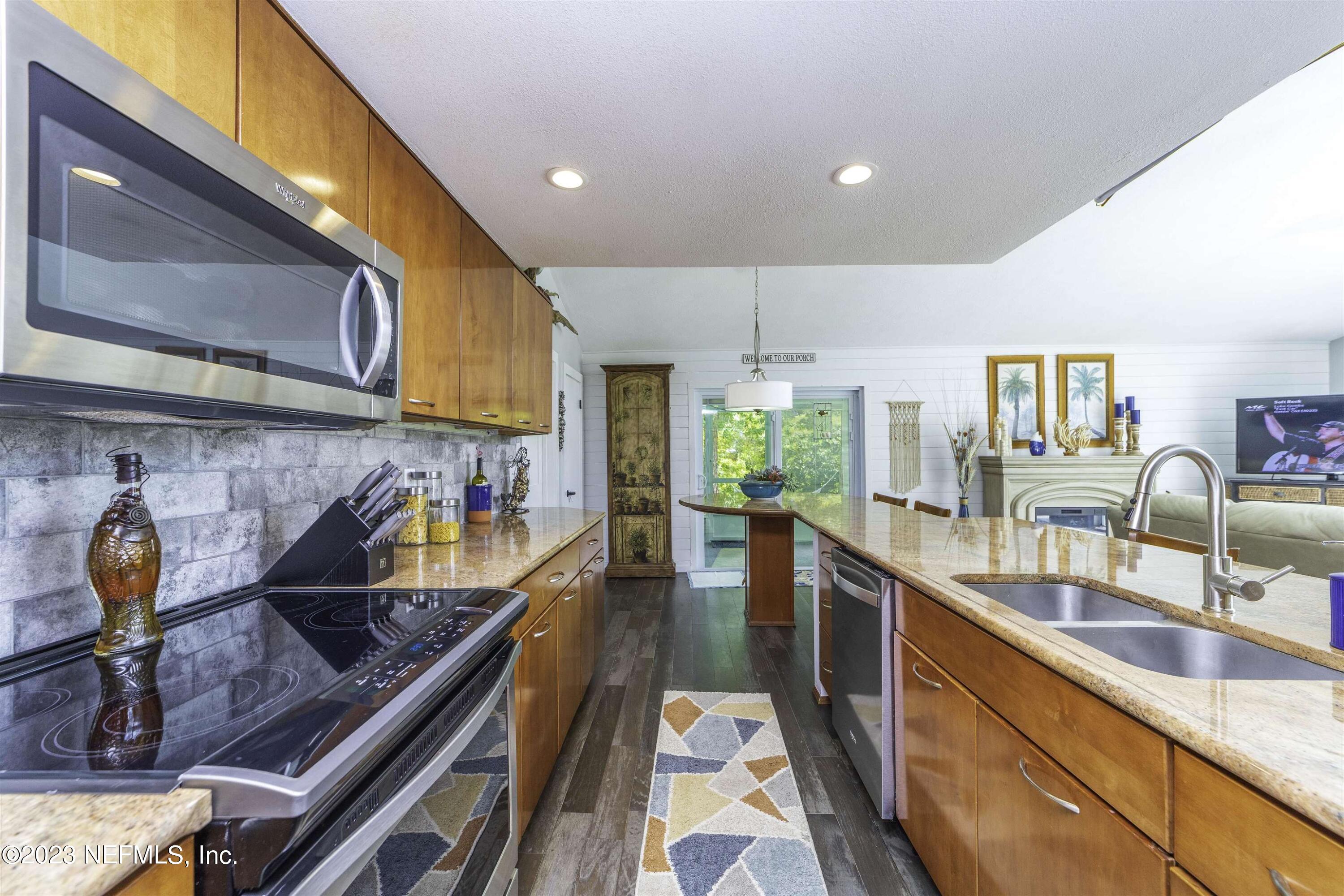 111 Loyola Road St. Augustine, FL 32086 - Photo 22 of 67 a kitchen with stainless steel appliances granite countertop a sink a stove and a wooden floors