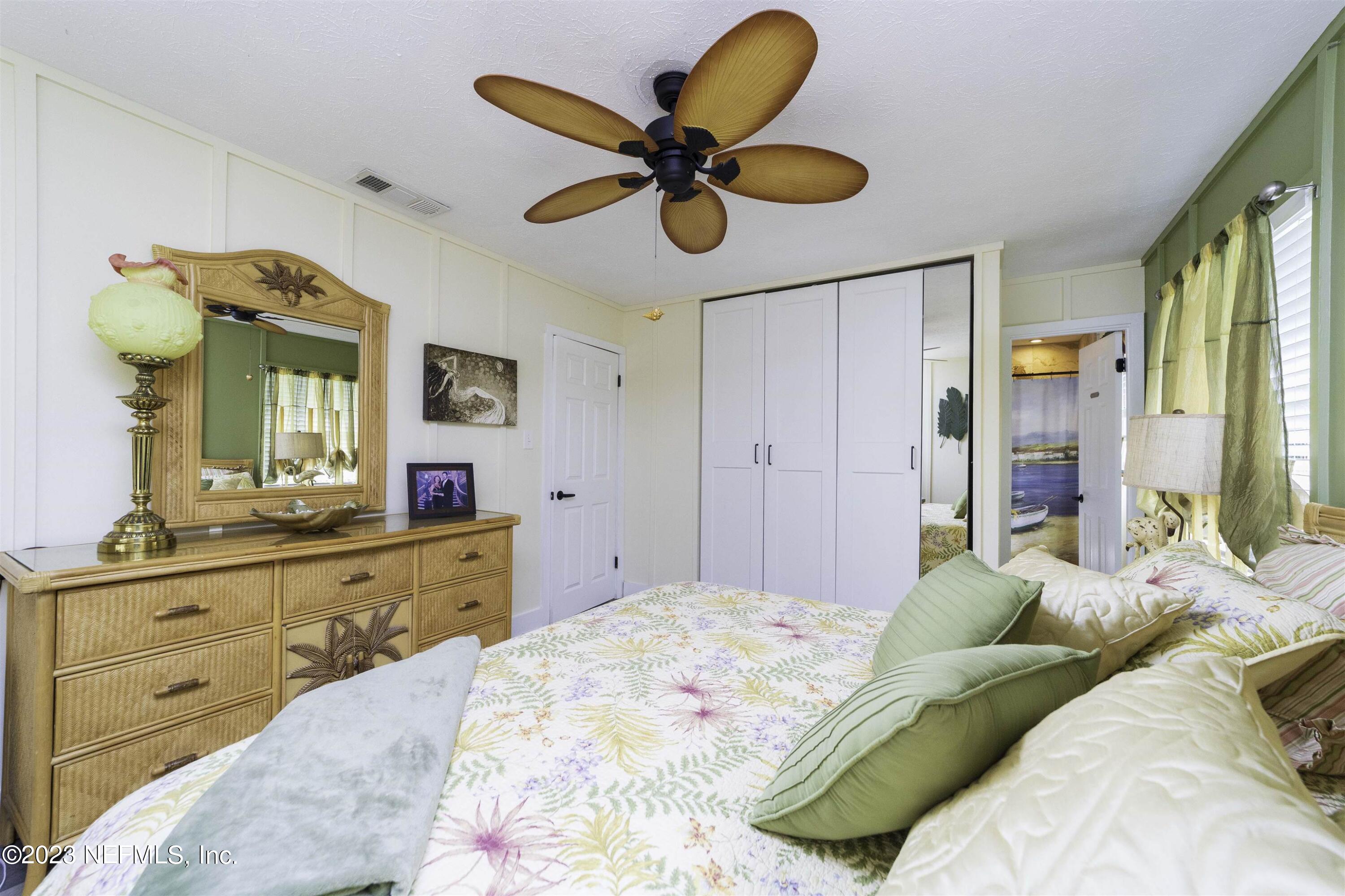 111 Loyola Road St. Augustine, FL 32086 - Photo 24 of 67 a bedroom with a bed and a chandelier