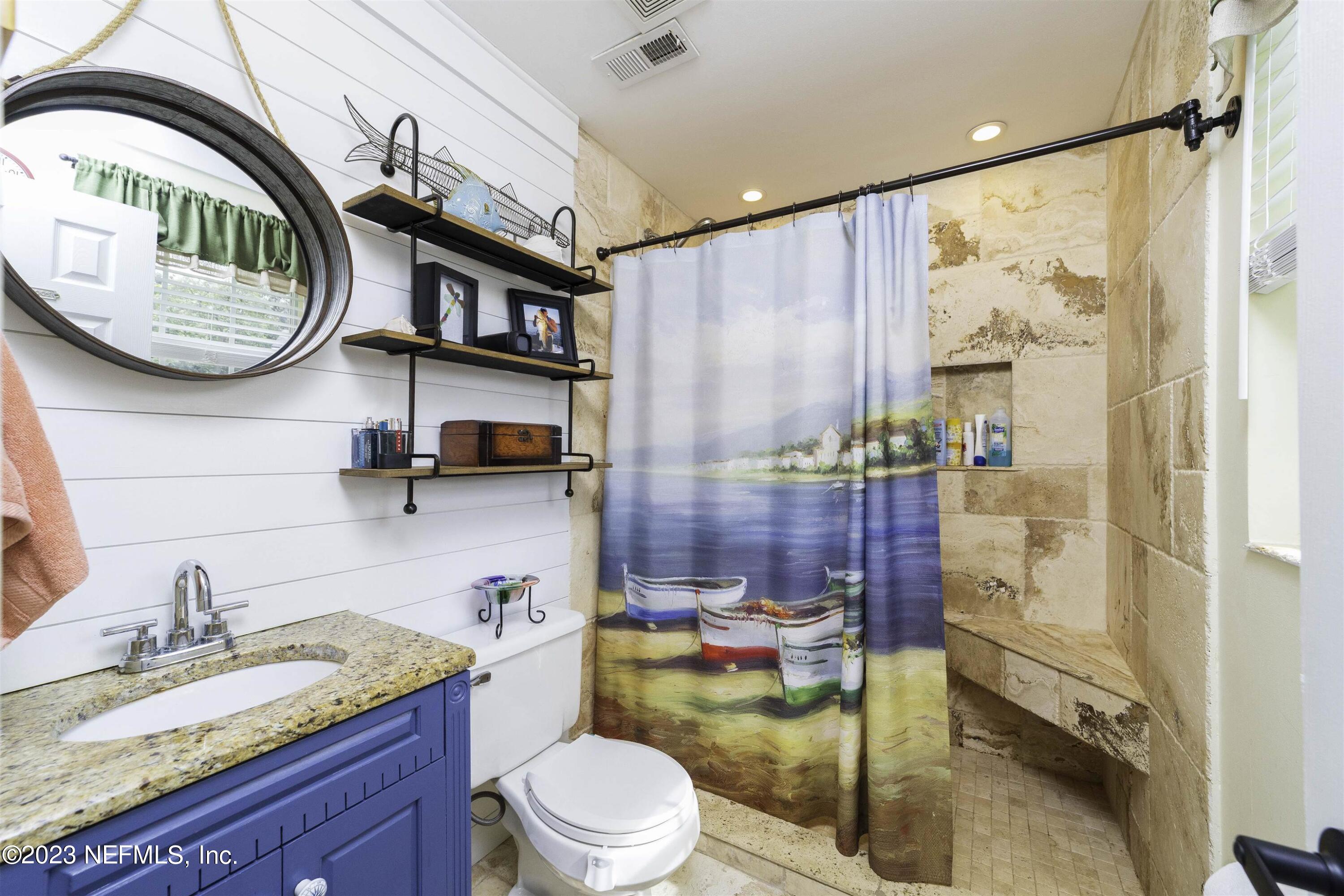 111 Loyola Road St. Augustine, FL 32086 - Photo 27 of 67 a bathroom with a granite countertop sink mirror vanity and toilet