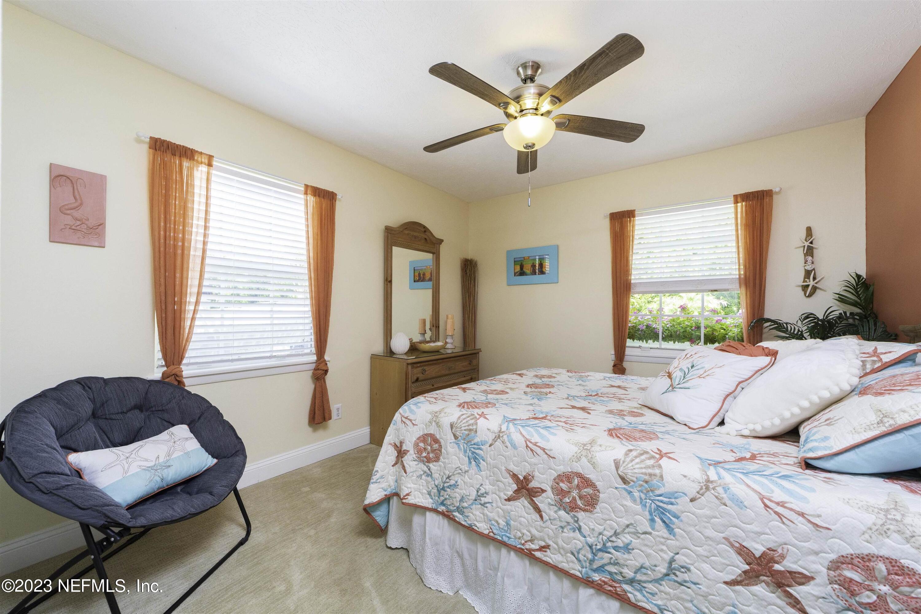 111 Loyola Road St. Augustine, FL 32086 - Photo 28 of 67 a bedroom with a bed and a chandelier