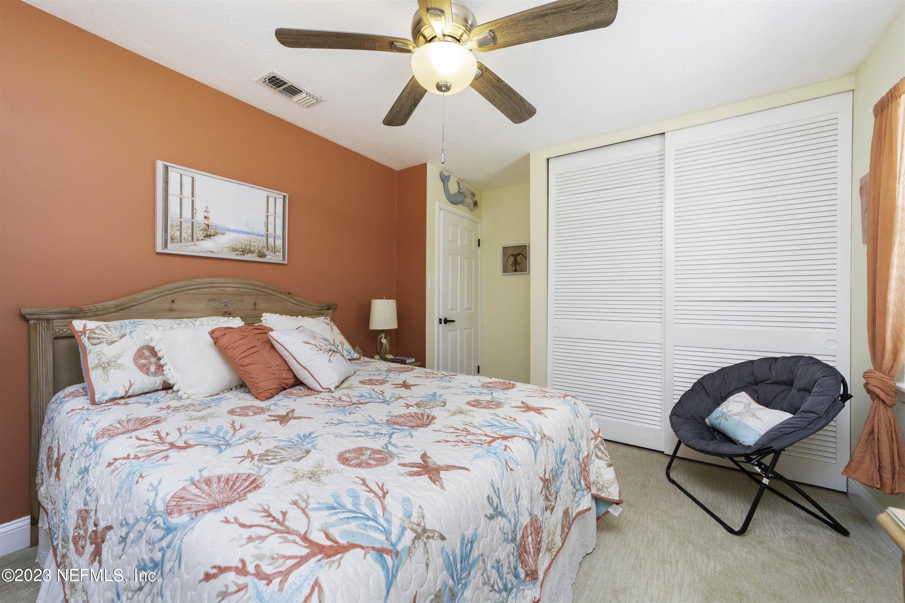 111 Loyola Road St. Augustine, FL 32086 - Photo 29 of 67 a bedroom with a bed and a chandelier