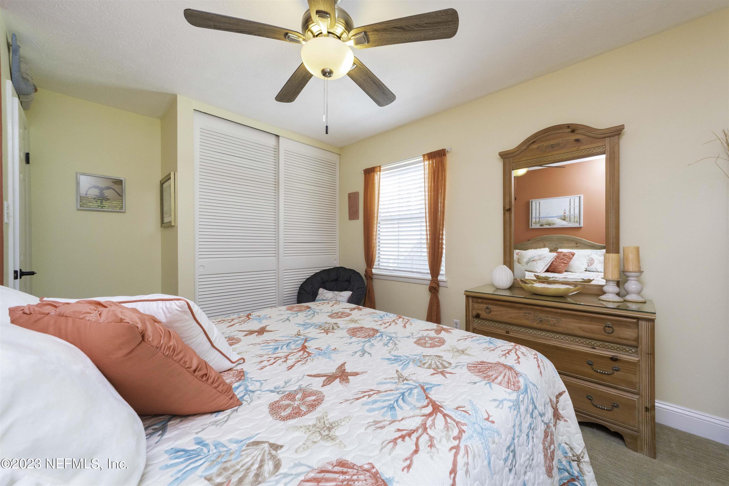 111 Loyola Road St. Augustine, FL 32086 - Photo 30 of 67 a bedroom with a bed and a chandelier