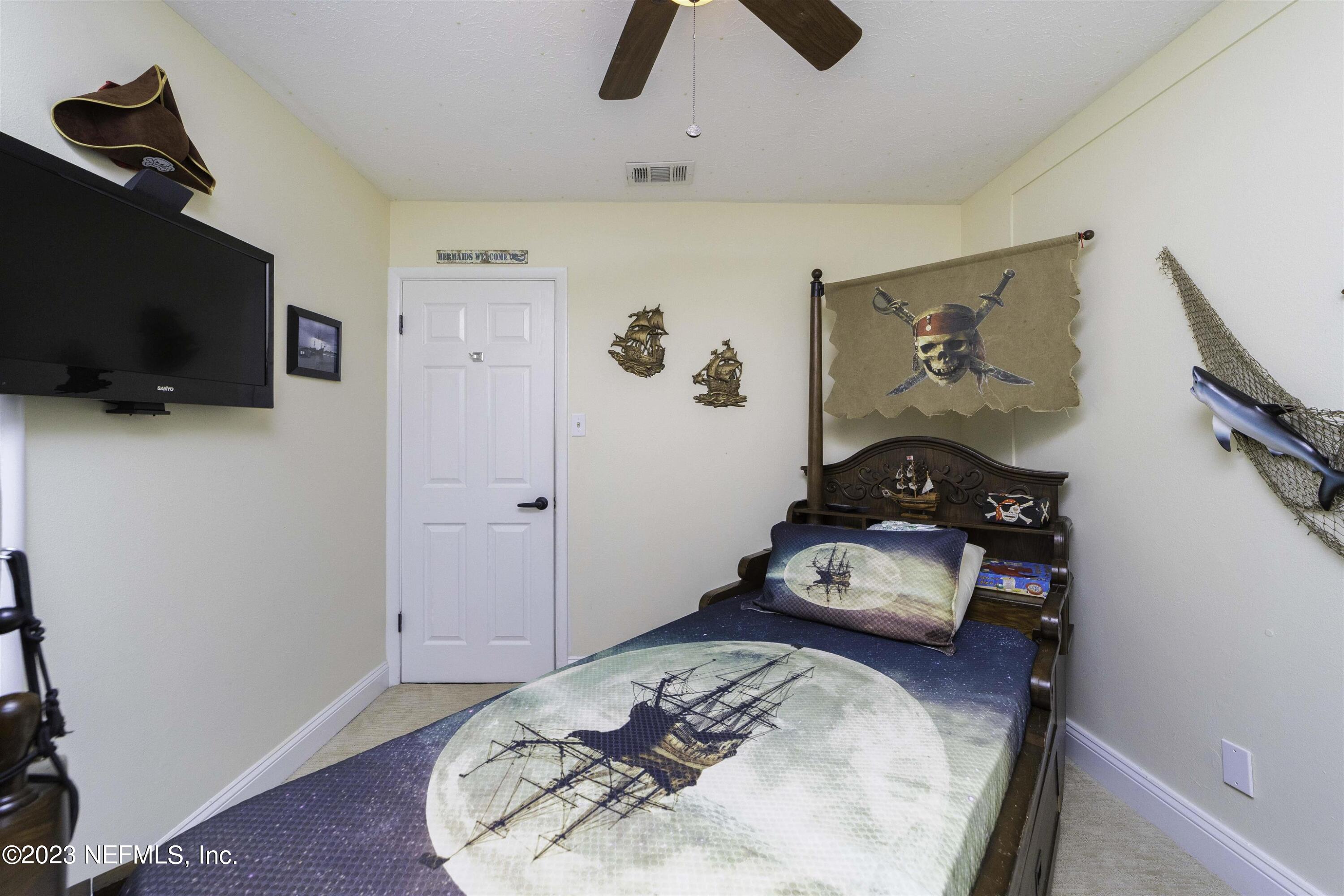 111 Loyola Road St. Augustine, FL 32086 - Photo 34 of 67 a bedroom with a bed and flat screen tv
