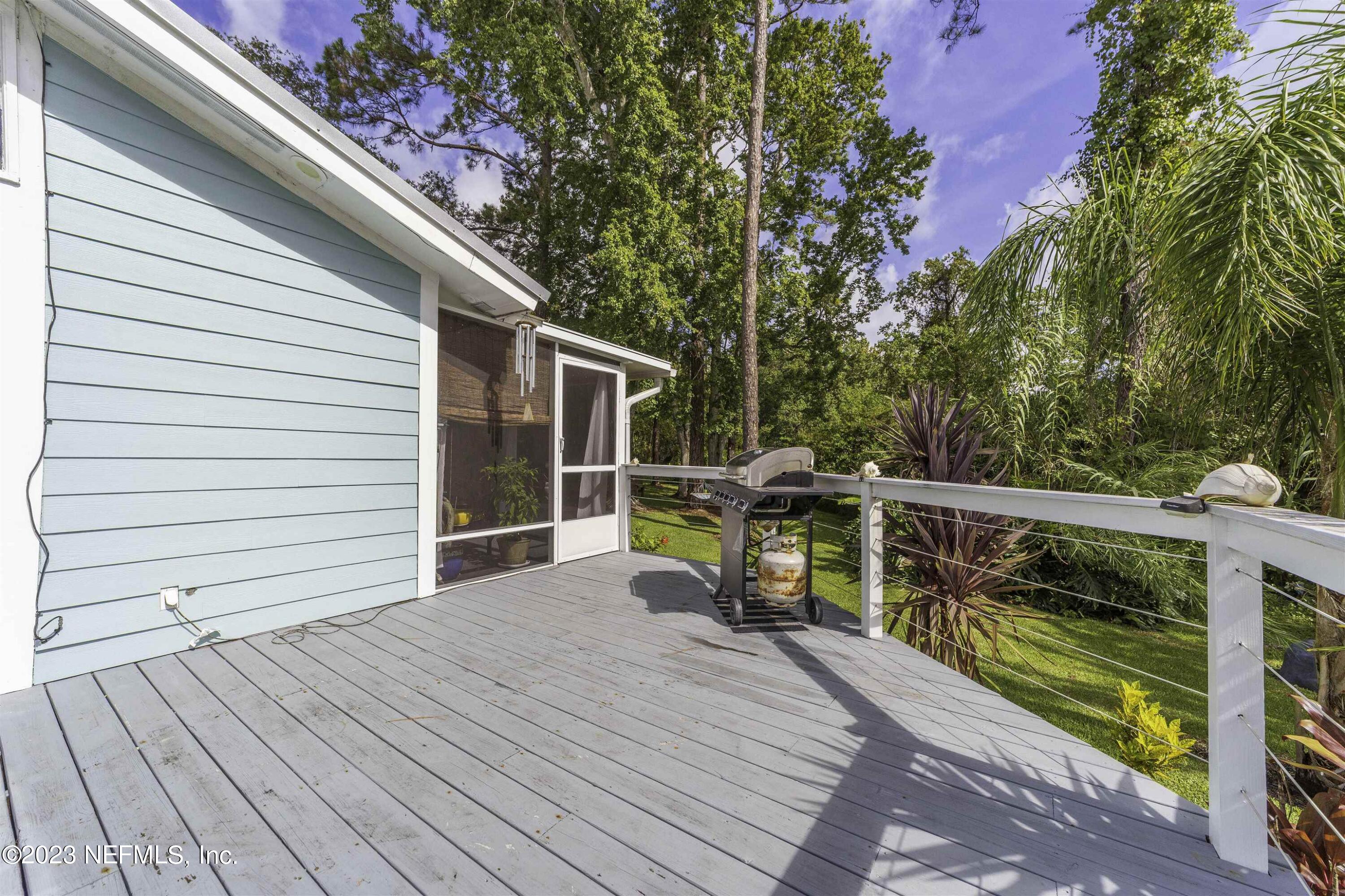 111 Loyola Road St. Augustine, FL 32086 - Photo 46 of 67 a view of a deck with wooden floor and fence next to a yard