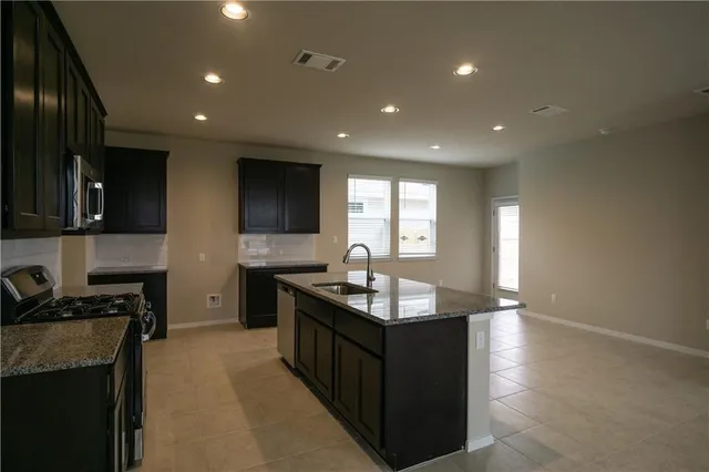 a kitchen with granite countertop a sink and cabinets
