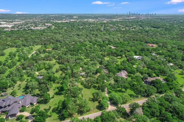 an aerial view of a houses with a yard and lake view