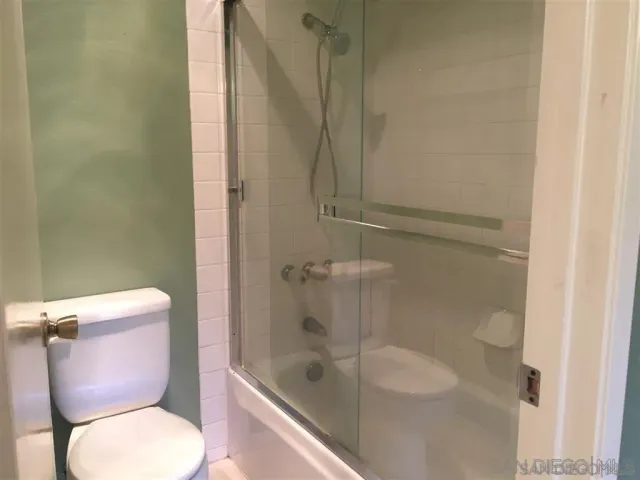 a white toilet sitting next to a bath tub