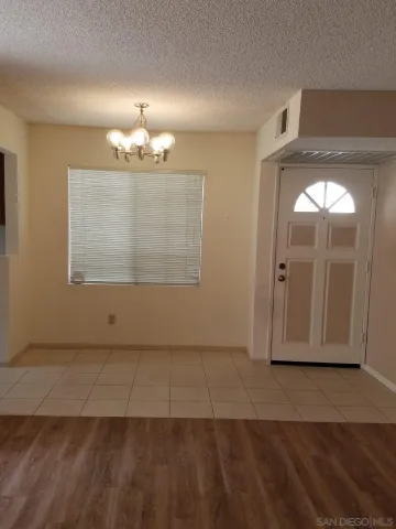 an empty room with wooden floor cabinet and mirrors