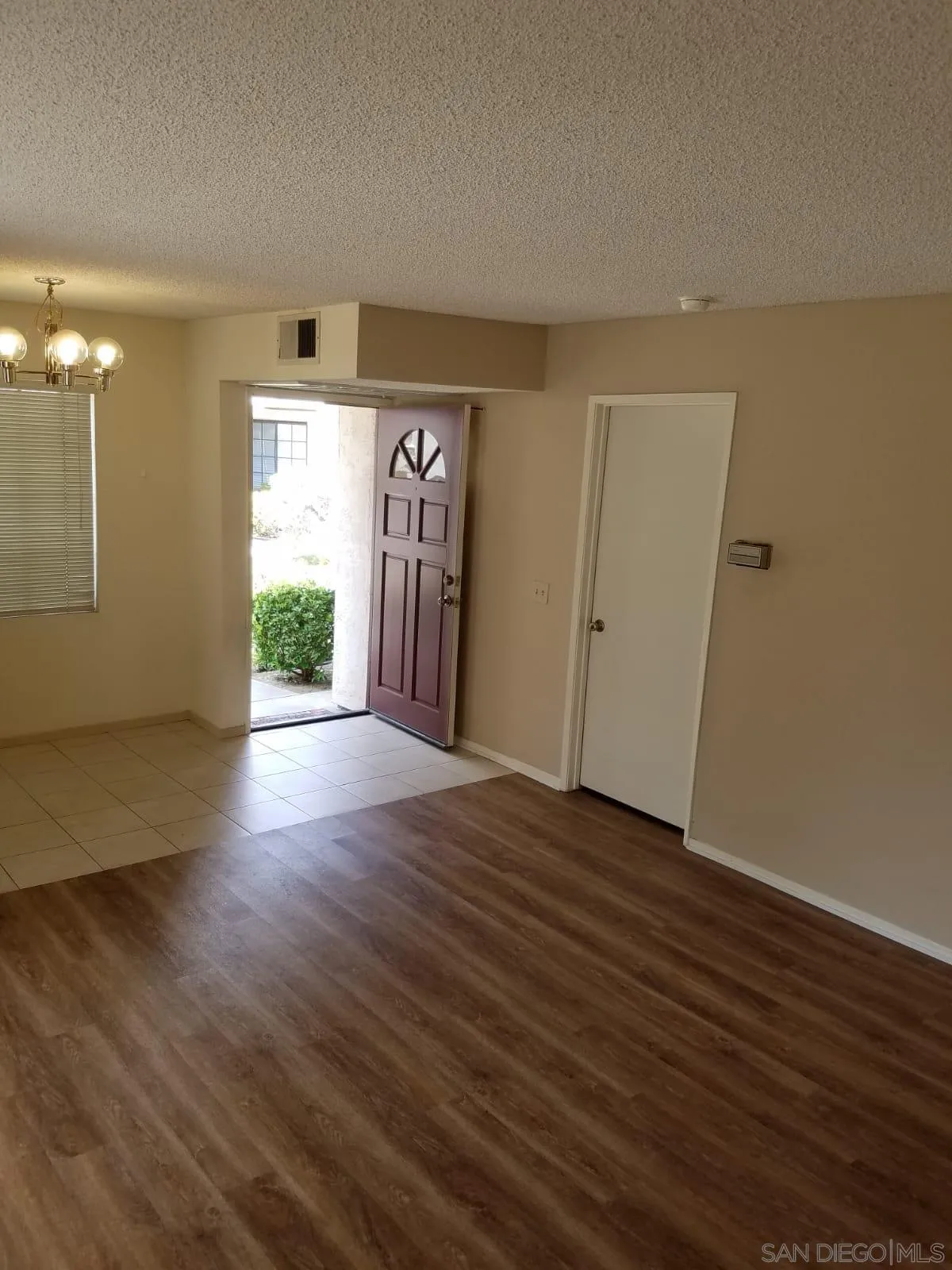 13294 Wimberly Square, Unit 228 San Diego, CA 92128 - Photo 5 of 24 an empty room with wooden floor and windows