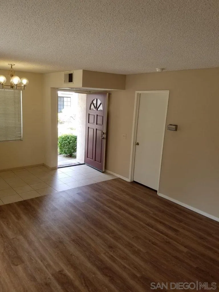 13294 Wimberly Square, Unit 228 San Diego, CA 92128 - Photo 9 of 24 an empty room with wooden floor and windows