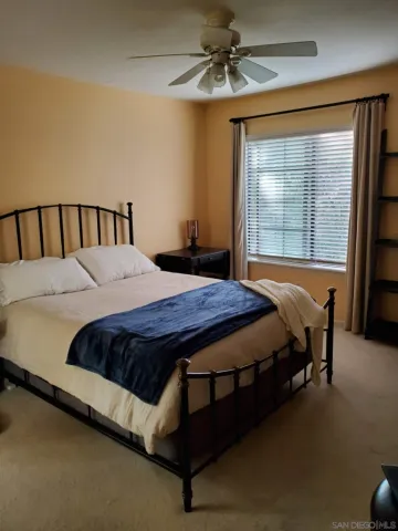 a bed sitting in a bedroom next to a window