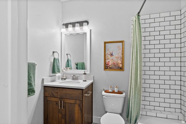 681 Island Road Morgan, UT 84050 - Photo 13 of 49 Bathroom featuring a white subway tile shower, wood-finish vanity with countertop, and framed mirror with integrated lighting