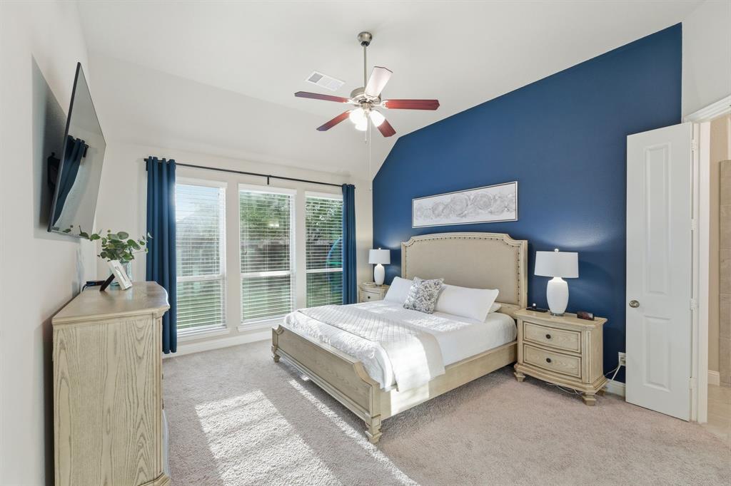 5105 Ember Place Little Elm, TX 76227 - Photo 15 of 35 a bedroom with a bed a chandelier and a flat tv screen on dresser