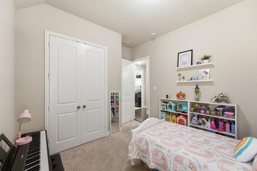 5105 Ember Place Little Elm, TX 76227 - Photo 22 of 35 a bedroom with a bed and a book shelf