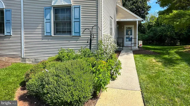 a view of a house with a yard and flower plants