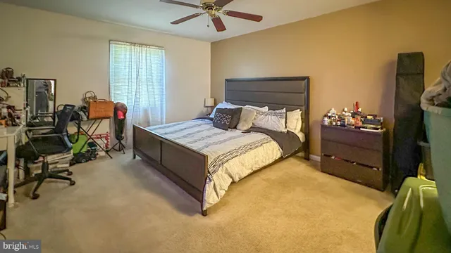 a bedroom with a bed and a flat tv screen on dresser