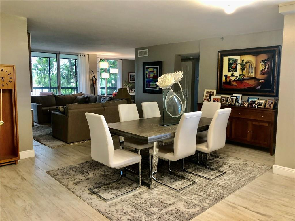 6463 La Costa Drive, Unit 305 Boca Raton, FL 33433 - Photo 13 of 20 a view of a dining room with furniture a rug and wooden floor