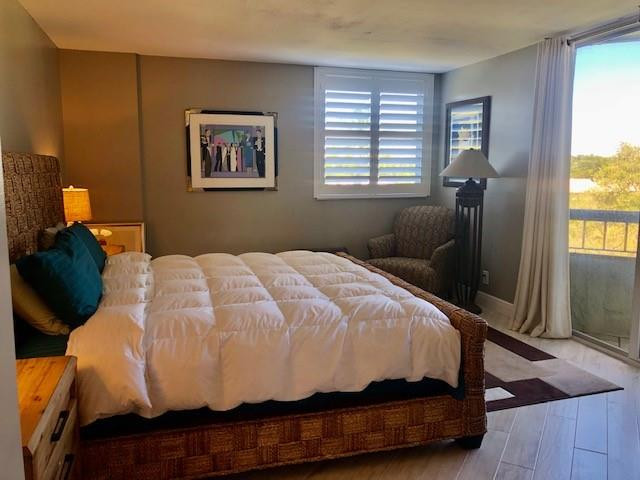 6463 La Costa Drive, Unit 305 Boca Raton, FL 33433 - Photo 15 of 20 a bedroom with a bed and wooden floor