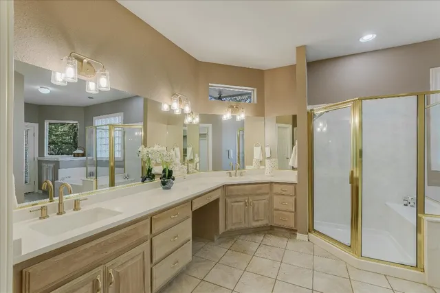 a large bathroom with a double vanity sink a large mirror and a shower
