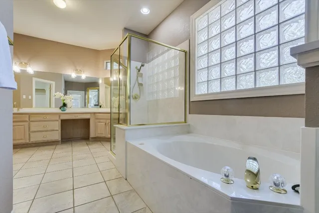 a bathroom with a bathtub a sink a vanity and a shower