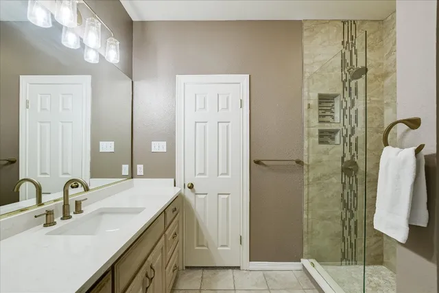 a bathroom with a double vanity sink and shower