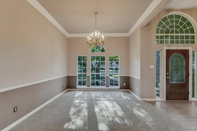 an empty room with windows and chandelier