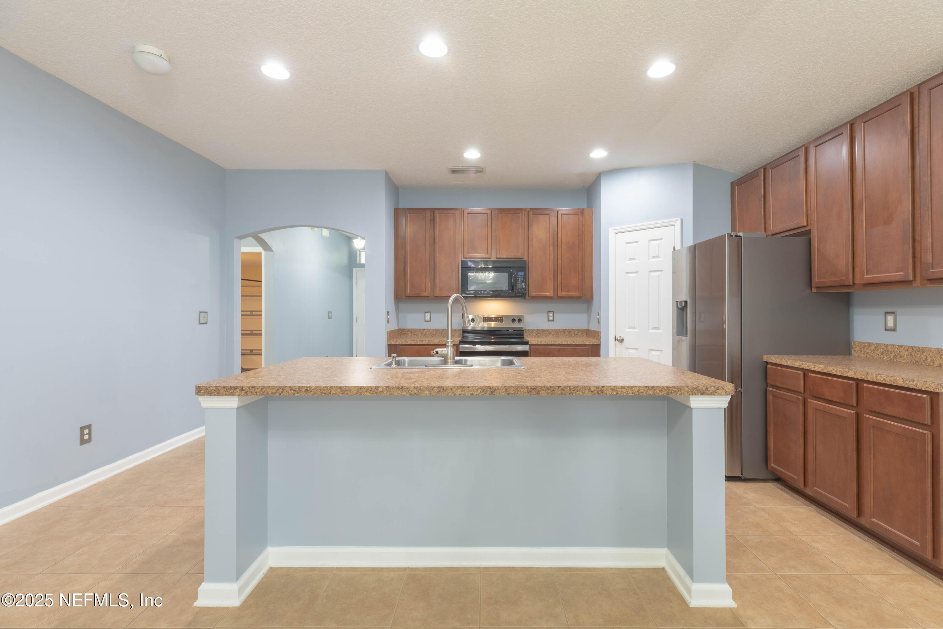211 Amber Ridge Road Jacksonville, FL 32218 - Photo 9 of 39 a kitchen with kitchen island granite countertop a sink a stove a refrigerator cabinets and wooden floor