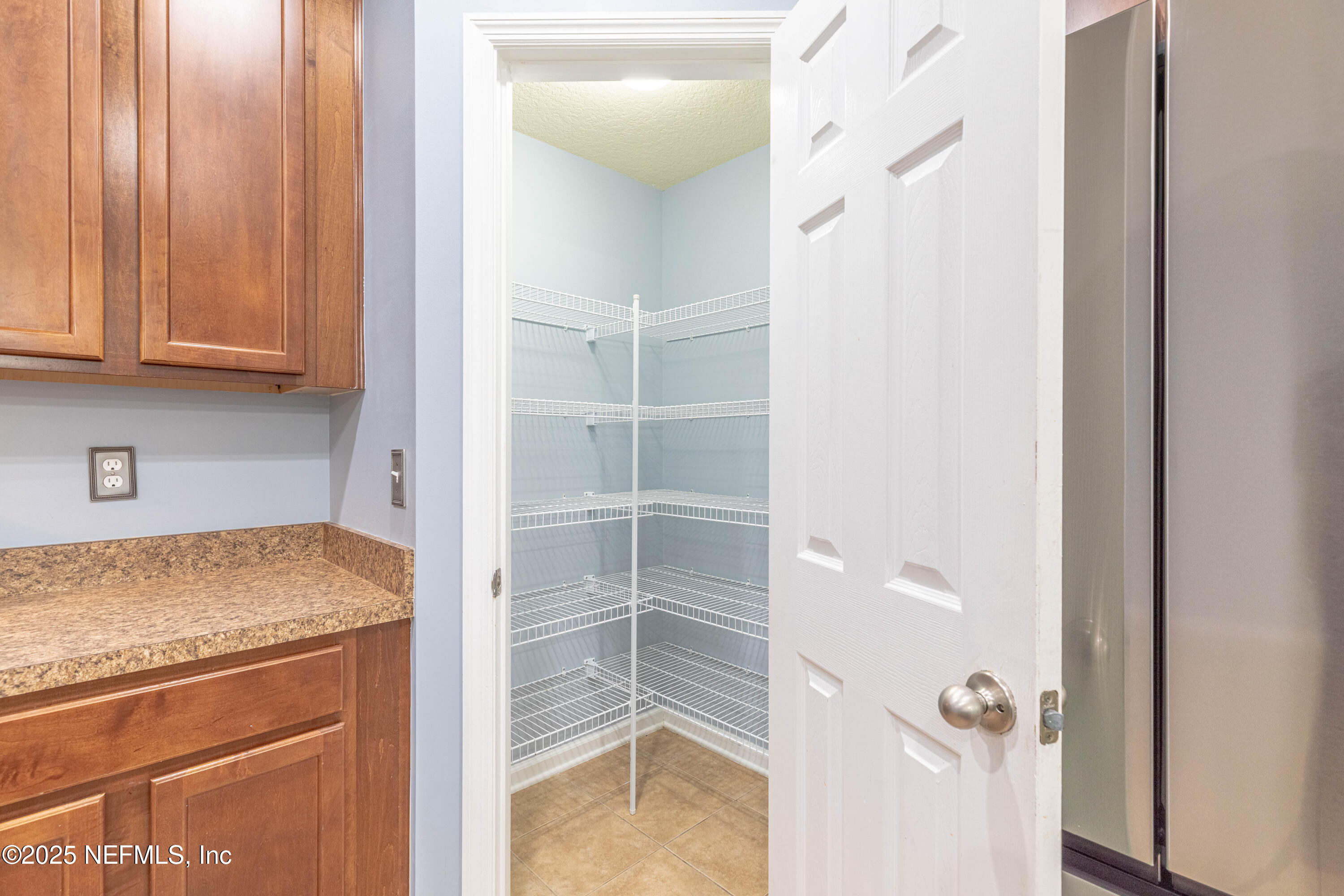 211 Amber Ridge Road Jacksonville, FL 32218 - Photo 10 of 39 a kitchen with a refrigerator and cabinets