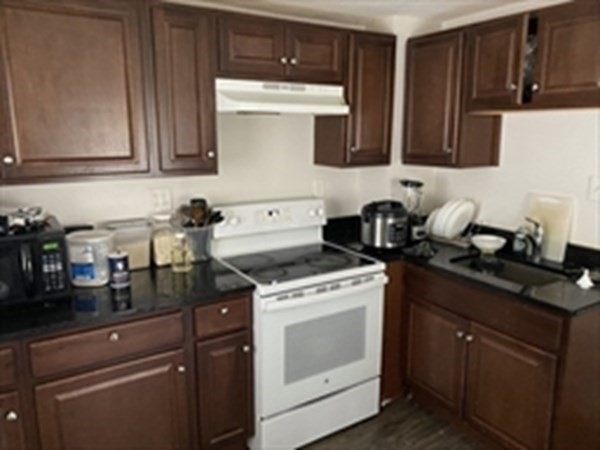 175 Hancock Street Everett, MA 02149 - Photo 8 of 15 a kitchen with stainless steel appliances granite countertop a sink a stove and cabinets