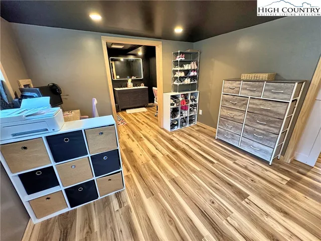 a hallway with a white cabinets and wooden floor