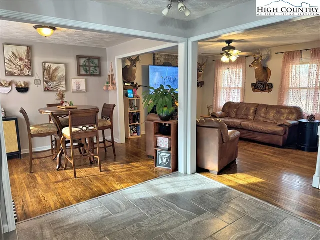 a living room with furniture and a dining table with kitchen view