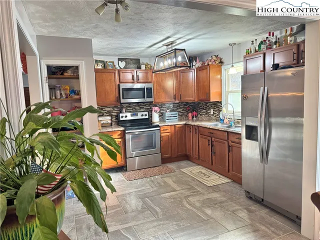 a kitchen with stainless steel appliances granite countertop a stove a sink dishwasher and a refrigerator