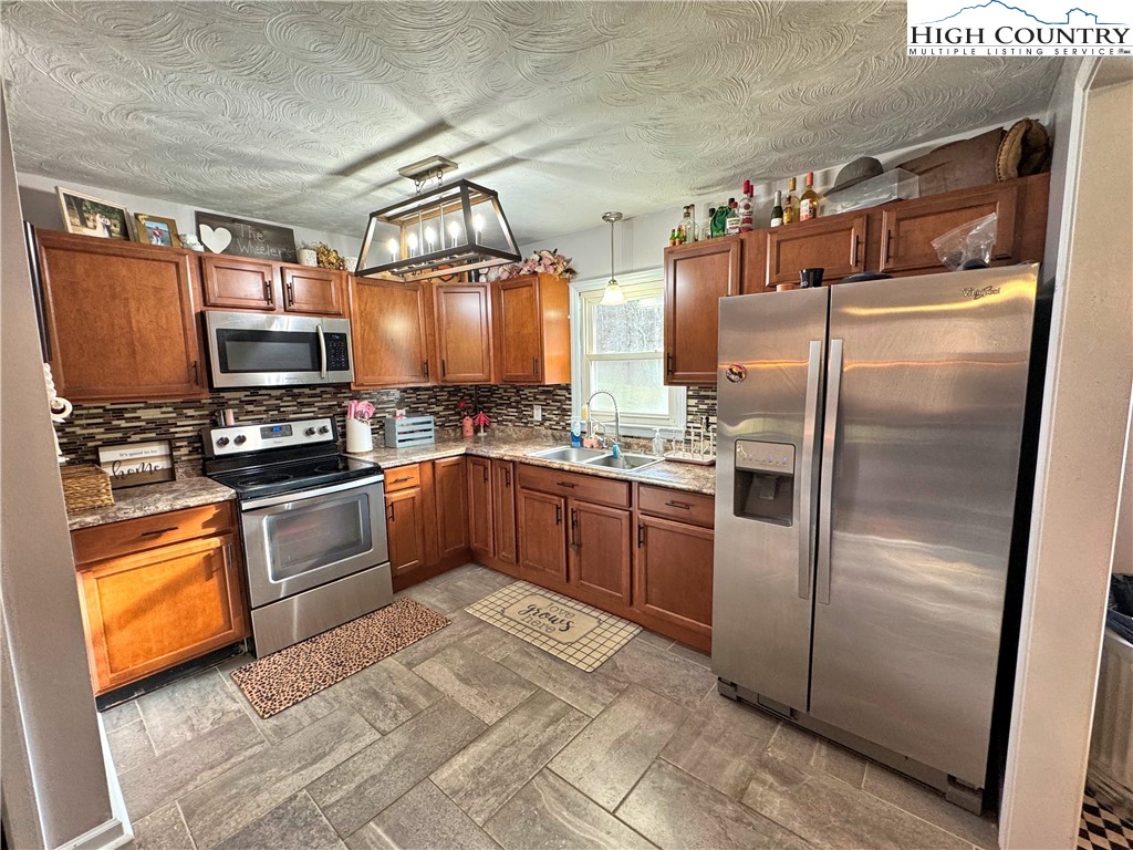 2047 Cline Road Rural Retreat, VA 24368 - Photo 7 of 35 a kitchen with granite countertop stainless steel appliances and wooden cabinets