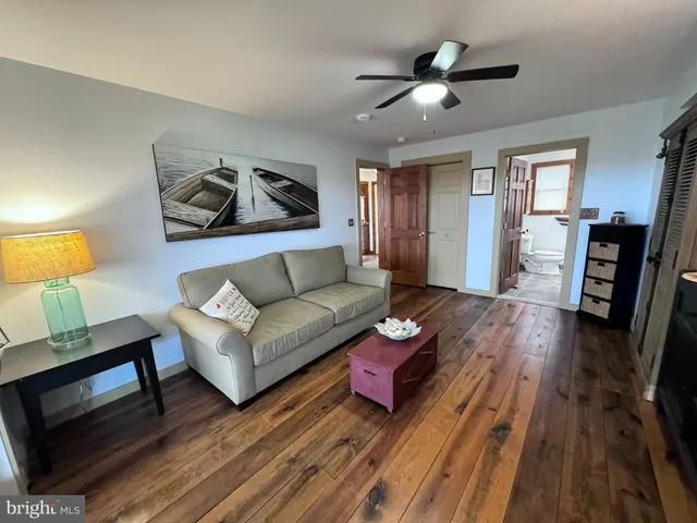 a kitchen with stainless steel appliances wooden floor and a sink